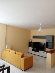 ein Wohnzimmer mit einem Sofa und einem Flachbild-TV in der Unterkunft La casa del ciliegio - appartamento a Caserta in Caserta