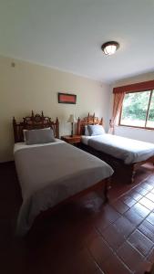 a bedroom with two beds and a window at Kwezi Cottage at The Great Rift Valley Lodge & Golf Resort Naivasha in Naivasha