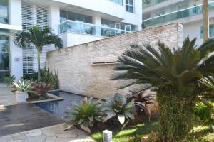 un patio con palmeras frente a un edificio en Apartamento Pé na Areia 212 - Apartamento Beira Mar 210 - Cabo Frio en Cabo Frío