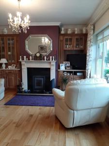 a living room with a white couch and a fireplace at Hillgrove House in Boyle