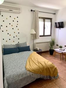 Un dormitorio con una cama con una manta amarilla. en La Calleja, en Hervás