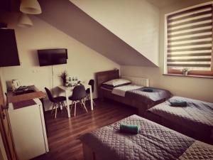 a room with two beds and a table with a desk at Dworcowa 10D in Płock