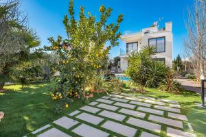 einen Garten mit einem Orangenbaum vor einem Haus in der Unterkunft Villa 11 Oasis del Mare, 5min Strand, Wifi, Klima, Fußbodenheizung in Sa Ràpita