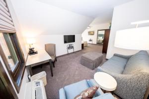 a living room with a couch and a tv at The Inn at Shattuck - St. Mary's in Faribault