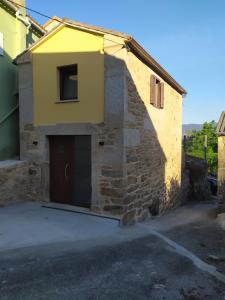 un edificio in pietra con una porta e un garage di A xanela a Outes