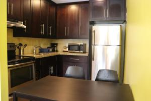 a kitchen with wooden cabinets and a refrigerator at Curtis Inn & Suites in Hollywood