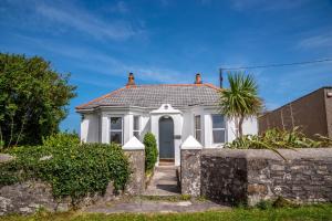 a white house with a gate and a fence at Finest Retreats - Western Watch - Sea Views, Pets Accepted, Sleeps 6 in Lower Boscaswell