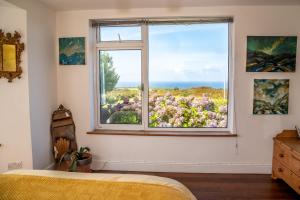 a bedroom with a window with a view of the ocean at Finest Retreats - Western Watch - Sea Views, Pets Accepted, Sleeps 6 in Lower Boscaswell