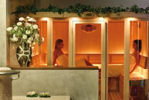 Dos mujeres en una sala de spa con un jarrón de flores en Locanda al Castello Wellness Resort en Cividale del Friuli