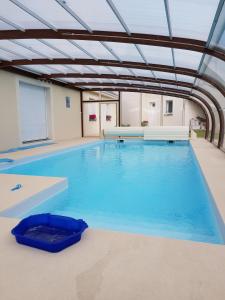 une grande piscine intérieure avec un plafond dans l'établissement gîte m et m, à Nébouzat