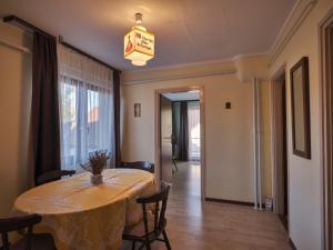 a dining room with a table and chairs and a light fixture at Hardy Apartman in Keszthely