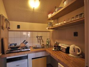 a small kitchen with a sink and a stove at Hardy Apartman in Keszthely