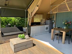 a living room with a couch and a table in a tent at Glamping aan de Plas in Vinkeveen