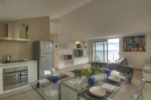 a kitchen with a glass table in a room at Residenza Ginepri 69 in Bergeggi