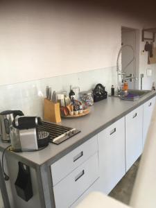 a kitchen with white cabinets and a counter top at Gardenhouse with private jacuzzi & private sauna in Teteringen