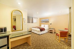 Habitación de hotel con cama y espejo en Glenwood Springs Inn en Glenwood Springs