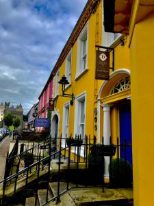 a yellow building with a blue door on a street at Dufferin Coaching Inn in Killyleagh