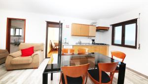 Il comprend une cuisine et un salon avec une table et des chaises. dans l'établissement Prime Oceanfront Apartment 2, à Ericeira