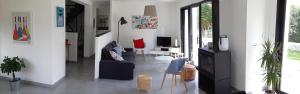 ein Wohnzimmer mit einem Sofa und einem Tisch in der Unterkunft COTE MER CHEMINEE 400 m de la plage 4 vélos in Bénodet