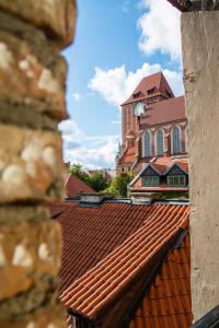 a church with a clock tower and a red roof at Wieża Janów by Rentoom in Toruń