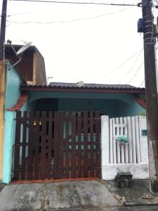 un cancello per una casa con una recinzione bianca di Casa Próximo Centro Itanhaém a Itanhaém