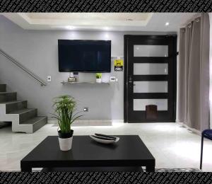 uma sala de estar com uma televisão e uma mesa de café preta em The Condo (by Modern Apartments) em Rosarito