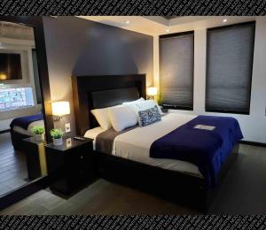 1 dormitorio con 1 cama extragrande y 2 ventanas en The Condo (by Modern Apartments) en Rosarito