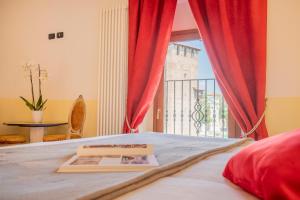 a bedroom with a bed with red curtains and a window at Corte Realdi Verona in Verona