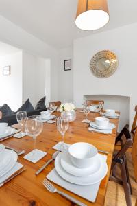 The World Famous Henderson House FREE PARKING في ليفربول: طاولة غرفة الطعام مع الأطباق البيضاء وكؤوس النبيذ