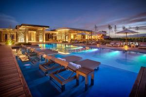 a swimming pool with lounge chairs and umbrellas at The Vines Resort & Spa in Los Sauces