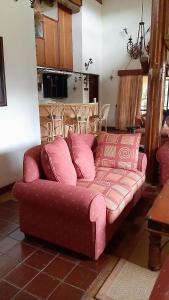 a couch in a living room with a pink couch at Kwezi Cottage at The Great Rift Valley Lodge & Golf Resort Naivasha in Naivasha