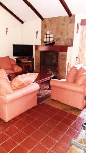 a living room with two couches and a fireplace at Kwezi Cottage at The Great Rift Valley Lodge & Golf Resort Naivasha in Naivasha