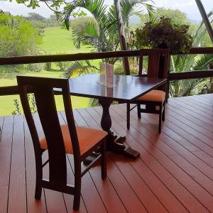 drewniany stół i krzesła na tarasie z widokiem w obiekcie Ol-Kine Cottage at The Great Rift Valley Lodge & Golf Resort Naivasha w mieście Naivasha