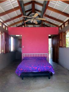 Un dormitorio con una pared rosa y una cama en WINDOWS AT THE SEA, en San Juanillo