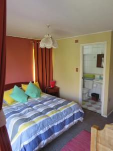 a bedroom with a bed and a bathroom at Hostal Blanca Estela in Concón