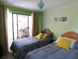 a bedroom with two beds next to a window at Hostal Blanca Estela in Concón