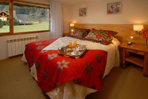 Un dormitorio con una cama con una bandeja de comida. en La Estancia Cabañas en Villa La Angostura