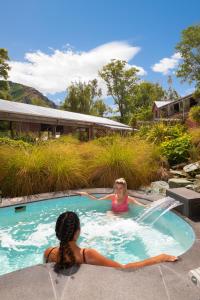 two women in a jacuzzi in a swimming pool at Millbrook Resort in Arrowtown