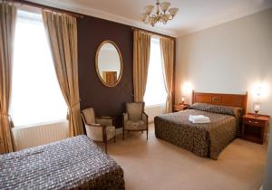 a hotel room with two beds and a mirror at Westenra Arms Hotel in Monaghan