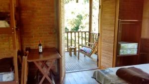 Zimmer mit einem Tisch und einer Tür zu einem Balkon in der Unterkunft Sítio Serra do Gigante in Cruzeiro