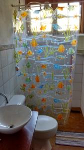 a bathroom with a shower curtain with fish on it at Sítio Serra do Gigante in Cruzeiro