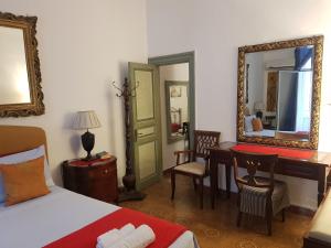 1 dormitorio con cama, escritorio y espejo en House Ròdue The Historic Center Palermo, en Palermo