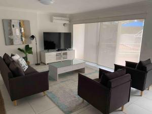 un soggiorno con 2 sedie e una TV a schermo piatto di Le Beach Apartments a Gold Coast