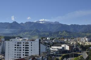 vistas a una ciudad con montañas en el fondo en Golden Frog Manizales en Manizales