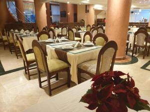 une rangée de tables et de chaises dans un restaurant dans l'établissement Hôtel Amouday, à Casablanca