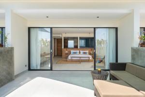 a living room with sliding glass doors leading to a bedroom at Adiwana Warnakali Resort in Nusa Penida +45 photos