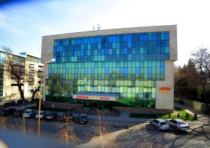 un gran edificio con coches estacionados frente a él en Astra Hotel, en Almaty