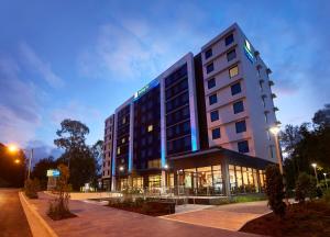 ein Hotelgebäude mit einer beleuchteten Fassade in der Nacht in der Unterkunft Holiday Inn Express Sydney Macquarie Park, an IHG Hotel in Sydney