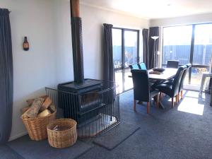 a living room with a wood stove and a table at Anglers Retreat in Lake Tekapo
