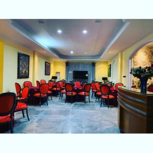 une salle de conférence avec des chaises rouges et un podium dans l'établissement BRIA Hotel & Convention, à Bogor